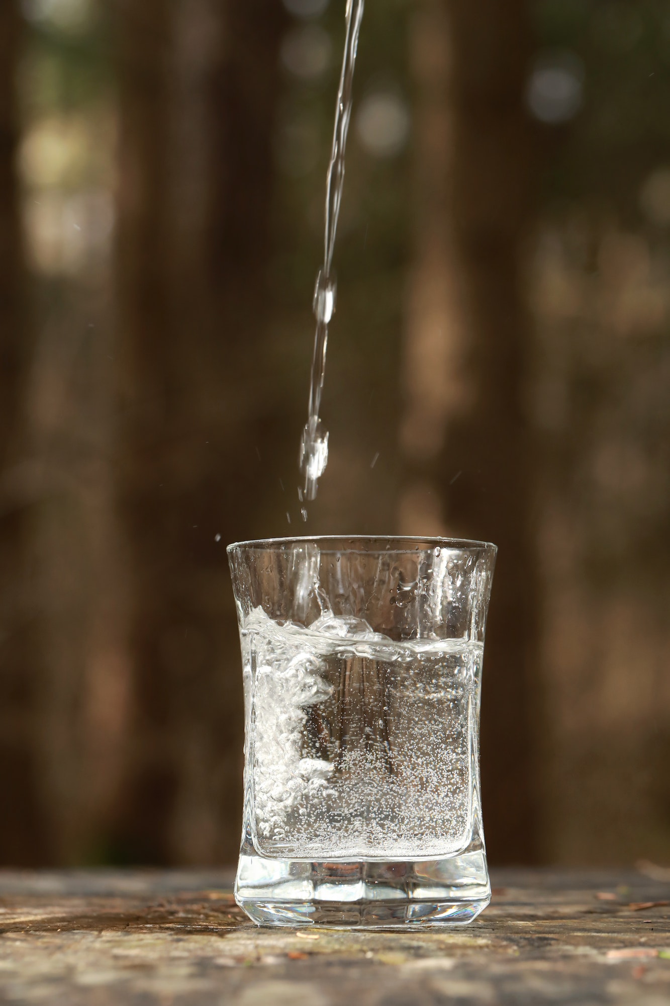 Water is poured into a transparent glass in nature.